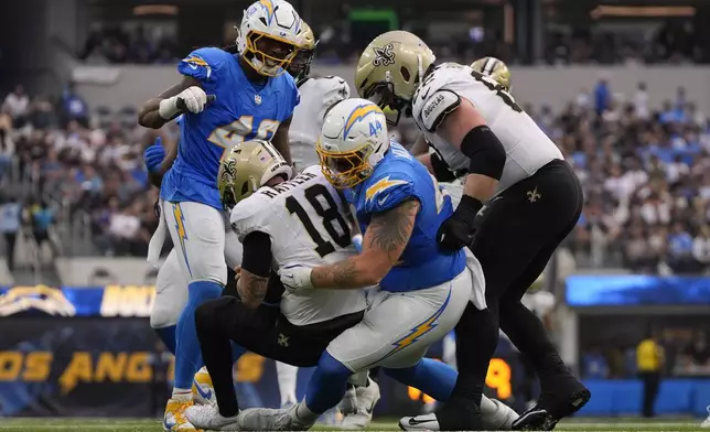 New Orleans Saints quarterback Spencer Rattler (18) is sacked by Los Angeles Chargers defensive tackle Scott Matlock (44) in the second half of an NFL football game in Inglewood, Calif., Sunday, Oct. 27, 2024. (AP Photo/Mark J. Terrill)