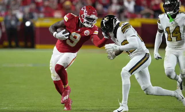 Kansas City Chiefs wide receiver JuJu Smith-Schuster (9) is forced out of bounds by New Orleans Saints cornerback Paulson Adebo after catching a pass during the first half of an NFL football game Monday, Oct. 7, 2024, in Kansas City, Mo. (AP Photo/Ed Zurga)