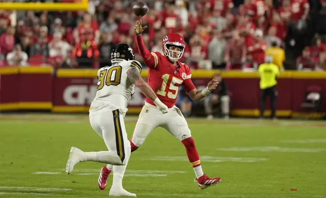 Kansas City Chiefs quarterback Patrick Mahomes (15) throws over New Orleans Saints defensive tackle Bryan Bresee (90) during the first half of an NFL football game Monday, Oct. 7, 2024, in Kansas City, Mo. (AP Photo/Charlie Riedel)