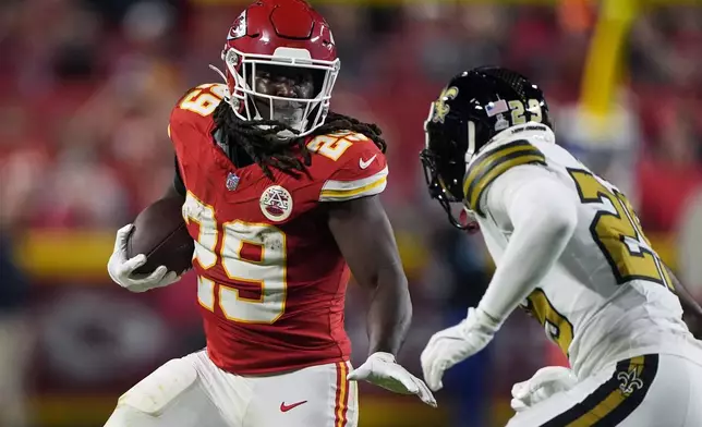 Kansas City Chiefs running back Kareem Hunt (29) runs with the ball as New Orleans Saints cornerback Paulson Adebo (29) defends during the first half of an NFL football game Monday, Oct. 7, 2024, in Kansas City, Mo. (AP Photo/Charlie Riedel)