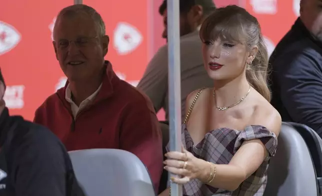 Taylor Swift arrives in a cart with her dad, Scott Swift, left, before the start of an NFL football game between the Kansas City Chiefs and the New Orleans Saints Monday, Oct. 7, 2024, in Kansas City, Mo. (AP Photo/Charlie Riedel)