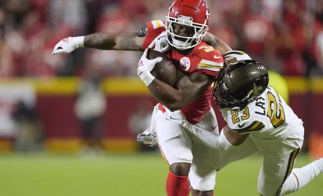 Kansas City Chiefs running back Samaje Perine, left, is stopped by New Orleans Saints cornerback Marshon Lattimore (23) during the first half of an NFL football game Monday, Oct. 7, 2024, in Kansas City, Mo. (AP Photo/Charlie Riedel)