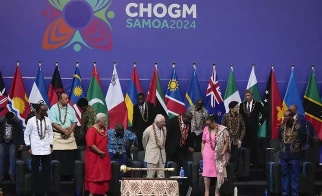 Britain's King Charles, centre, stands with delegates during the opening ceremony for the Commonwealth Heads of Government meeting in Apia, Samoa, Friday, Oct. 25, 2024. (AP Photo/Rick Rycroft/Pool)