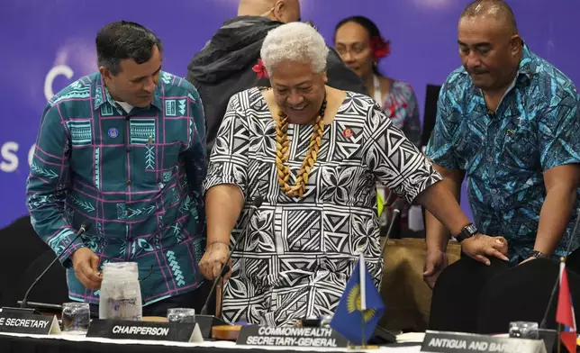 Samoan Prime Minister Afioga Fiamē Naomi Mataʻafa, center, is assisted by Assistant Secretary General of the Commonwealth Luis Franceschi, left, at the Foreign Ministers meeting at the Commonwealth Heads of Government meeting in Apia, Samoa, Thursday, Oct. 24, 2024. (AP Photo/Rick Rycroft/Pool)