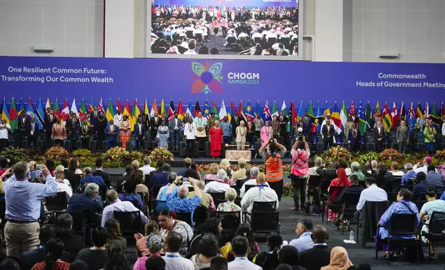 Britain's King Charles stands with the delegates for a family photo during the opening ceremony for the Commonwealth Heads of Government meeting in Apia, Samoa, Friday, Oct. 25, 2024. (AP Photo/Rick Rycroft/Pool)