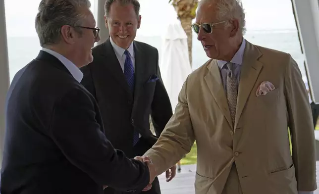 Britain's King Charles III, right, shakes hands with Britain's Prime Minister Keir Starmer at a reception the King is hosting for for heads of government and spouses/partners attending the Commonwealth Heads of Government Meeting (CHOGM) in Apia, Samoa, on Friday, Oct. 25, 2024. (Samoa CHOGM 2024/Pool Photo via AP)