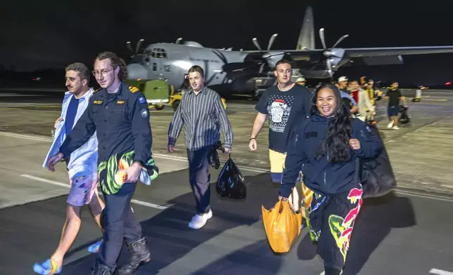 In this image released by New Zealand Defence Force (NZDF), crew of the HMNZS Manawanui that sank in Samoa on Oct. 6, 2024, walk from their plane after landing at RNZAF Base Auckland, from Samoa, in Whenuapai, New Zealand, Monday, Oct. 7, 2024. (Petty Officer Chris Weissenborn/NZDF via AP)