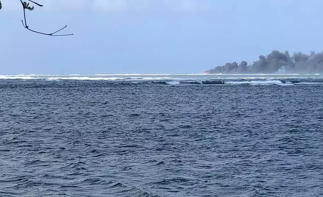 Smoke rises from the sinking HMNZS Manawanui in Upolu, Samoa, Sunday, Sept. 6, 2022. (Dave Poole via AP)