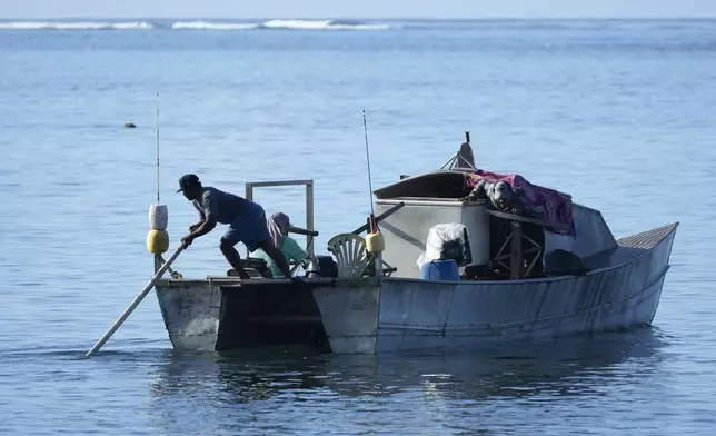 Fishermen from in the village of Siumu, Samoa, prepare to leave on Tuesday, Oct. 22, 2024, to fish near the New Zealand navy ship HMNZS Manawanui thats sank not far from the village. (AP Photo/Rick Rycroft)