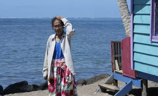 Netina Malae walks past a hut at her Sima PJ Beach Fale resort in the village of Tafitoala, Samoa, on Monday, Oct. 21, 2024, near where a New Zealand navy ship ran aground and sank on Oct. 6. (AP Photo/Rick Rycroft)