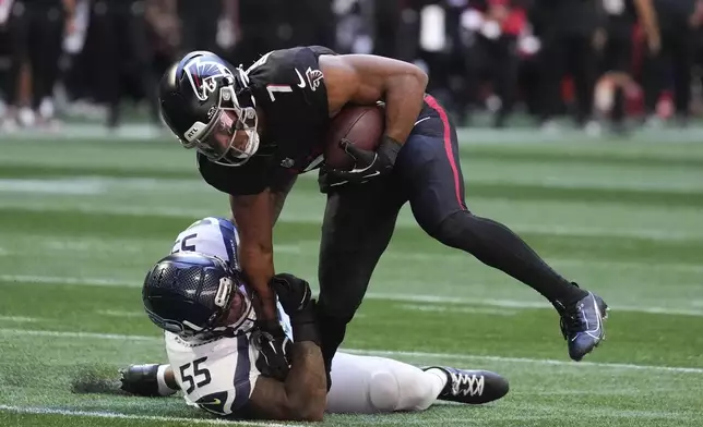 Atlanta Falcons running back Bijan Robinson (7) is tackled by Seattle Seahawks defensive end Dre'Mont Jones (55) during the second half of an NFL football game, Sunday, Oct. 20, 2024, in Atlanta. (AP Photo/ Brynn Anderson)