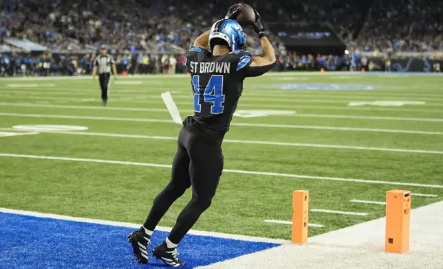 Detroit Lions wide receiver Amon-Ra St. Brown (14) catches a 8-yard reception for a touchdown during the second half of an NFL football game against the Seattle Seahawks, Monday, Sept. 30, 2024, in Detroit. (AP Photo/Paul Sancya)