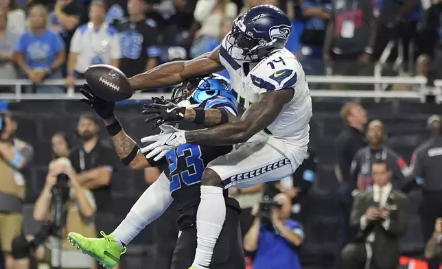 Detroit Lions cornerback Carlton Davis III (23) deflects a pass intended for Seattle Seahawks wide receiver DK Metcalf (14) during the second half of an NFL football game, Monday, Sept. 30, 2024, in Detroit. (AP Photo/Paul Sancya)