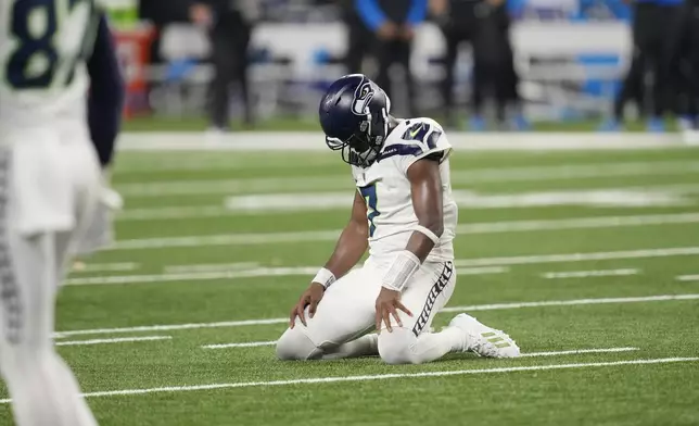 Seattle Seahawks quarterback Geno Smith kneels on the field after a play during the second half of an NFL football game against the Detroit Lions, Monday, Sept. 30, 2024, in Detroit. (AP Photo/Paul Sancya)