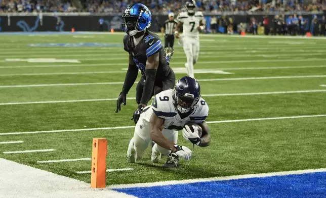 Detroit Lions safety Kerby Joseph (31) misses the tackle on Seattle Seahawks running back Kenneth Walker III (9) as Walker dives for a 21-yard rushing touchdown during the second half of an NFL football game, Monday, Sept. 30, 2024, in Detroit. (AP Photo/Paul Sancya)