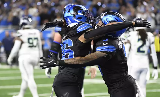 Detroit Lions running back Jahmyr Gibbs, left, celebrates his touchdown with running back David Montgomery during the first half of an NFL football game against the Seattle Seahawks, Monday, Sept. 30, 2024, in Detroit. (AP Photo/Jose Juarez)