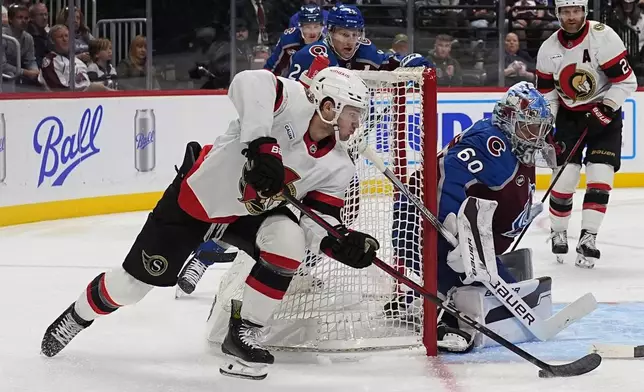 Ottawa Senators center Josh Norris, left, sweeps around the net to shoot against Colorado Avalanche goaltender Justus Annunen (60) in the second period of an NHL hockey game Sunday, Oct. 27, 2024, in Denver. (AP Photo/David Zalubowski)