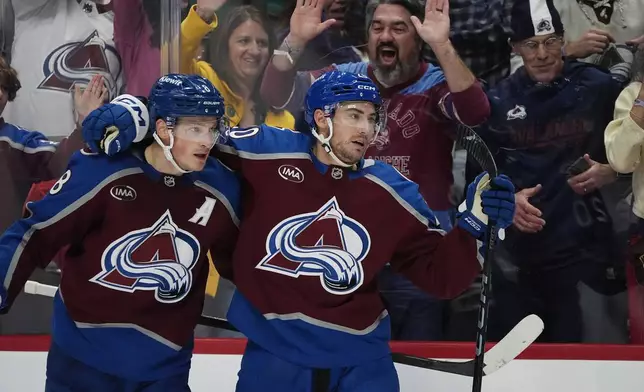 Colorado Avalanche defenseman Cale Makar, left, congratulates center Ross Colton after his goal against the Ottawa Senators in the third period of an NHL hockey game Sunday, Oct. 27, 2024, in Denver. (AP Photo/David Zalubowski)