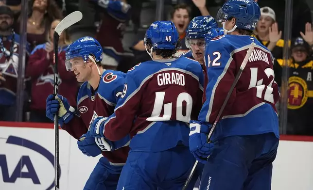 Colorado Avalanche right wing Logan O'Connor, left, is congratulated after scoring a goal by defensemen Samuel Girard, second from left, and Josh Manson, right, in the third period of an NHL hockey game against the Ottawa Senators, Sunday, Oct. 27, 2024, in Denver. (AP Photo/David Zalubowski)