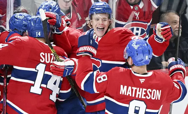 Montreal Canadiens players celebrate a goal by teammate Cole Caufield during the third period of an NHL hockey game, Saturday, Oct. 12, 2024, in Montreal. (Graham Hughes/Canadian Press via AP)