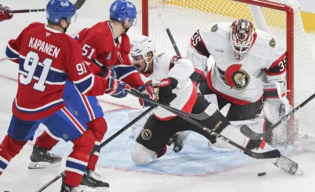 Ottawa Senators' Travis Hamonic (23) blocks a shot as Montreal Canadiens' Oliver Kapanen (91) and Emil Heineman (51) move in on Senators goaltender Linus Ullmark during the second period of an NHL hockey game, Saturday, Oct. 12, 2024 in Montreal. (Graham Hughes/Canadian Press via AP)