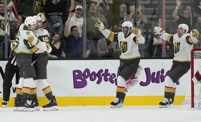 Vegas Golden Knights celebrate after Vegas Golden Knights center Nicolas Roy (10) scored against the Ottawa Senators during the first period of an NHL hockey game Friday, Oct. 25, 2024, in Las Vegas. (AP Photo/John Locher)