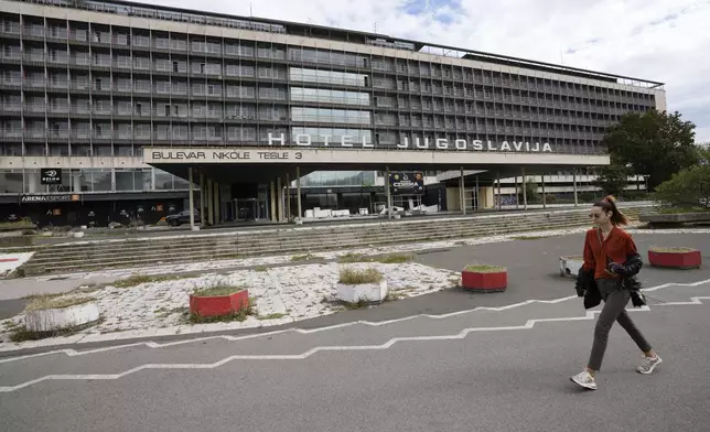 A woman walks past Hotel Yugoslavia, once a symbol of progress in the former socialist state of Yugoslavia that broke apart in the 1990s and a favorite gathering place for local residents as well as world leaders, in Belgrade, Serbia, Thursday, Oct. 3, 2024. (AP Photo/Darko Vojinovic)