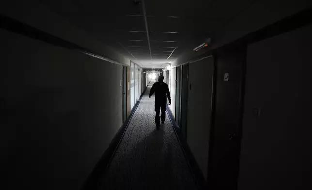 A security worker walks through Hotel Yugoslavia, once a symbol of progress in the former socialist state of Yugoslavia that broke apart in the 1990s and a favorite gathering place for local residents as well as world leaders, in Belgrade, Serbia, Thursday, Oct. 3, 2024. (AP Photo/Darko Vojinovic)