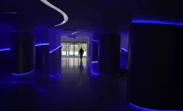 A security worker walks through Hotel Yugoslavia, once a symbol of progress in the former socialist state of Yugoslavia that broke apart in the 1990s and a favorite gathering place for local residents as well as world leaders, in Belgrade, Serbia, Thursday, Oct. 3, 2024. (AP Photo/Darko Vojinovic)