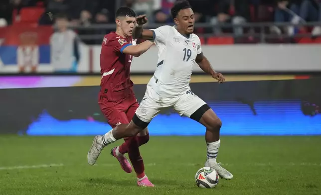 Serbia's Kosta Nedeljkovic fouls Switzerland's Dan Ndoye inside the penalty box during the UEFA Nations League soccer match between Serbia and Switzerland at the Dubocica Stadium in Leskovac, Serbia, Saturday, Oct. 12, 2024. (AP Photo/Darko Vojinovic)