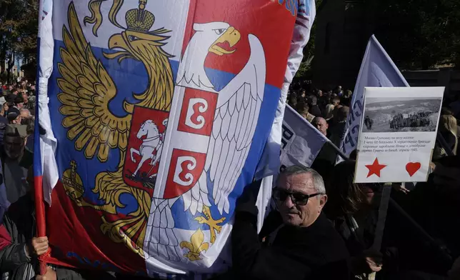 A man waves a flag that shows Russian, left, and Serbian flags during a ceremony on the occasion of the 80th anniversary of the liberation of Belgrade from Nazi occupation in WWII by Soviet and local communist fighters, in Belgrade, Serbia, Sunday, Oct. 20, 2024. (AP Photo/Darko Vojinovic)