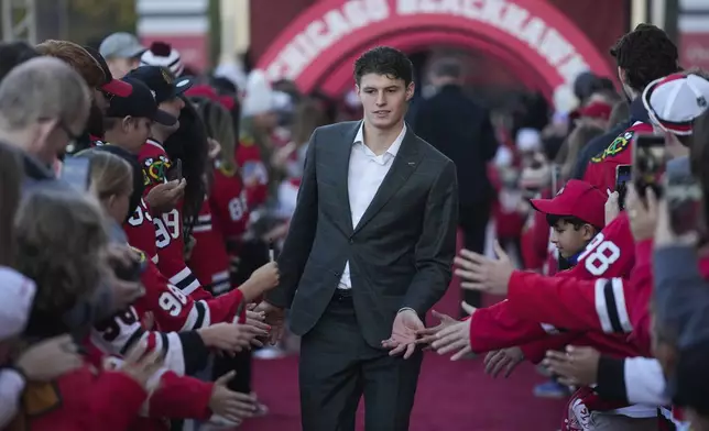 Chicago Blackhawks left wing Lukas Reichel walks the red carpet before the Blackhawks' home opener NHL hockey game against the San Jose Sharks, Thursday, Oct. 17, 2024, in Chicago. (AP Photo/Erin Hooley)