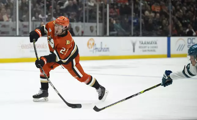 Anaheim Ducks center Mason McTavish (23) shoots past San Jose Sharks center Mikael Granlund (64) during the third period of an NHL hockey game, Tuesday, Oct. 22, 2024, in Anaheim, Calif. (AP Photo/Kyusung Gong)