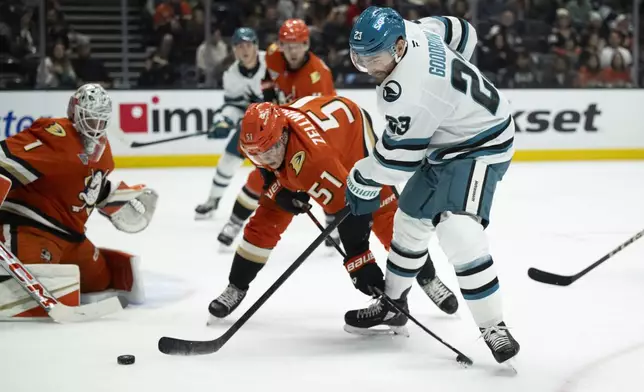 San Jose Sharks right wing Barclay Goodrow (23) shoots as Anaheim Ducks defenseman Olen Zellweger (51) defends during the second period of an NHL hockey game, Tuesday, Oct. 22, 2024, in Anaheim, Calif. (AP Photo/Kyusung Gong)