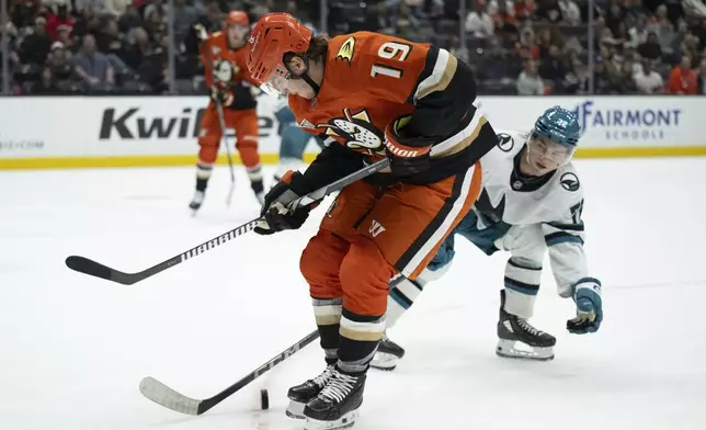 Anaheim Ducks right wing Troy Terry (19) and San Jose Sharks left wing William Eklund vie for the puck during the first period of an NHL hockey game, Tuesday, Oct. 22, 2024, in Anaheim, Calif. (AP Photo/Kyusung Gong)