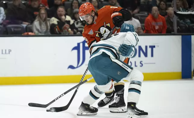 Anaheim Ducks right wing Troy Terry shoots as San Jose Sharks defenseman Jack Thompson (26) defends during the first period of an NHL hockey game, Tuesday, Oct. 22, 2024, in Anaheim, Calif. (AP Photo/Kyusung Gong)