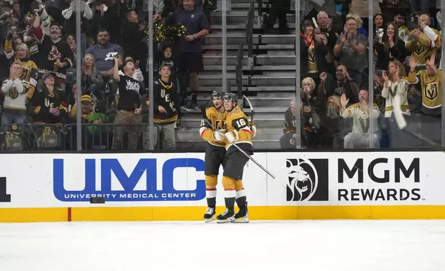 Vegas Golden Knights center Brett Howden (21), left, celebrates with left wing Pavel Dorofeyev (16) after scoring a goal against the San Jose Sharks during the first period of an NHL hockey game Saturday, Oct. 26, 2024, in Las Vegas. (AP Photo/Lucas Peltier)
