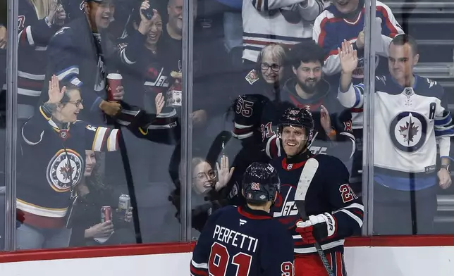 Winnipeg Jets' Nikolaj Ehlers (27) and Cole Perfetti (91) celebrate after Ehlers' goal against the San Jose Sharks during first-period NHL hockey game action in Winnipeg, Manitoba, Friday, Oct. 18, 2024. (John Woods/The Canadian Press via AP)