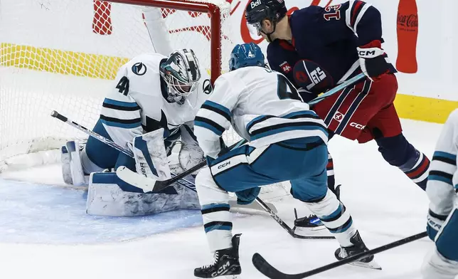 San Jose Sharks goaltender Vitek Vanecek (41) saves the shot from Winnipeg Jets' Gabriel Vilardi (13) as Cody Ceci (4) defends during the second period of an NHL hockey game, Friday, Oct. 18, 2024 in Winnipeg, Manitoba. (John Woods/The Canadian Press via AP)