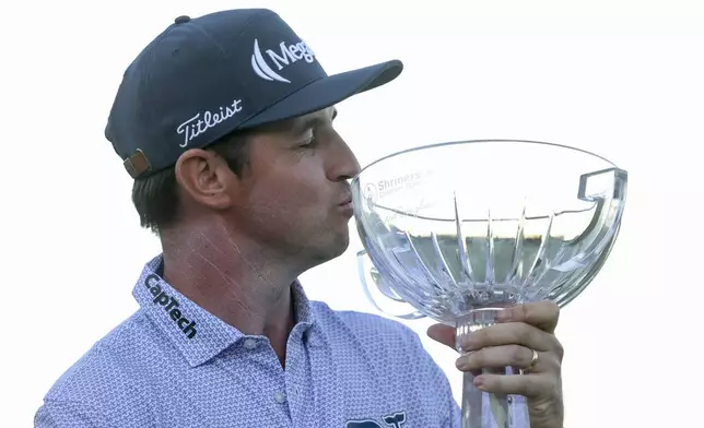 J.T. Poston kisses the trophy after winning the Shriners Children's Open golf tournament, Sunday, Oct. 20, 2024, in Las Vegas. (AP Photo/Ian Maule)