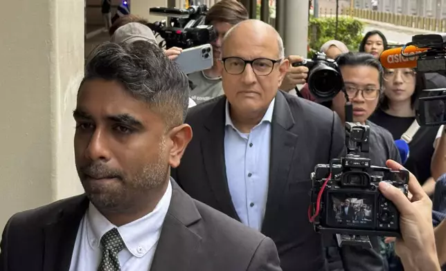 Former Transport Minister S. Iswaran, center, and his lawyer Navin Thevar arrive at the High Court in Singapore, July 5, 2024. (AP Photo)