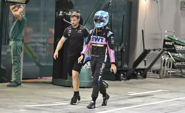 Alpine driver Pierre Gasly of France walks through pits during the qualifying session of the Singapore Formula One Grand Prix at the Marina Bay Street Circuit, in Singapore, Saturday, Sept. 21, 2024. (Mohd Rasfan/Pool Photo via AP)