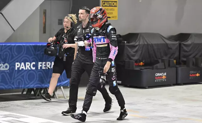 Alpine driver Esteban Ocon of France walks through pits during the qualifying session of the Singapore Formula One Grand Prix at the Marina Bay Street Circuit, in Singapore, Saturday, Sept. 21, 2024. (Mohd Rasfan/Pool Photo via AP)