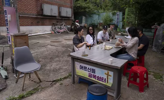 Nicole Motta, second from left, an adoptee visiting from Los Angeles, chats with Paek Kyeong-mi from Global Overseas Adoptees' Link, during a break from searching for Motta's birth family in Bucheon, South Korea, Thursday, May 30, 2024. (AP Photo/Jae C. Hong)