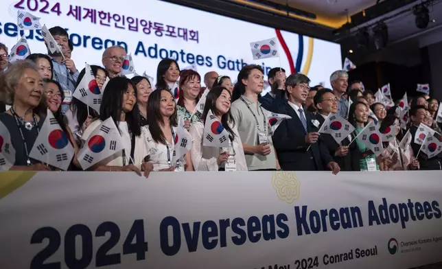 Maja Andersen, front row third from left, an adoptee visiting from Denmark to search for her birth family, holds a South Korean flag with others while taking a group photo at the Overseas Korean Adoptees Gathering in Seoul, South Korea, Tuesday, May 21, 2024. These adoptees are among the 200,000 sent away from Korea to Western nations as children. (AP Photo/Jae C. Hong)