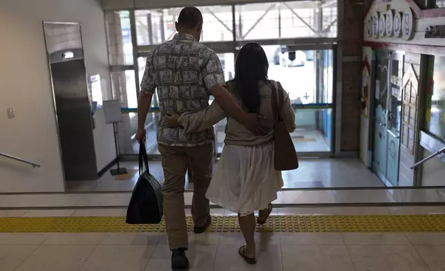 Kenneth Barthel, left, who was abandoned and later adopted to the United States at 6 years old, and his wife, Napela, comfort each other as they leave the Busan Metropolitan City Child Protection Center in Busan, South Korea, Friday, May 17, 2024, after searching for documents that could lead to finding his birth family. (AP Photo/Jae C. Hong)