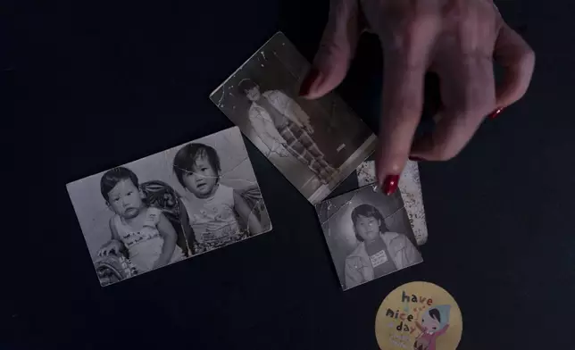 Yooree Kim, who was sent to a couple in France by the Holt adoption agency when she was 11, displays some old photos of her and her brother in her apartment in Seoul, Saturday, May 18, 2024. (AP Photo/Jae C. Hong)