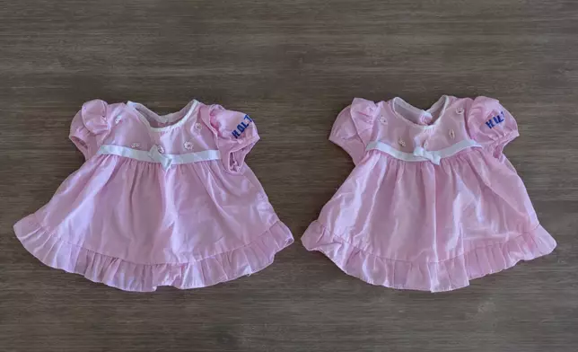 The baby outfits of twin sisters Dee Iraca and Becca Webster, worn on their trip from South Korea when adopted by a family in the United States, are displayed in Iraca's home Saturday, April 6, 2024, in Davidson, N.C. (AP Photo/David Goldman)