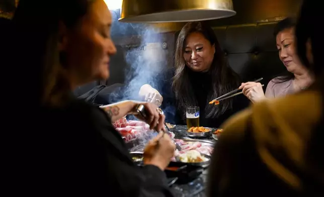 Rebecca Kimmel, center, eats with fellow Korean adoptees, Jenny Kelly, left, and Michelle Leco, right, at Yetgol Old Village Korean BBQ Sunday, Jan. 28, 2024, in Seattle. Kimmel still does not know, and may never know, who she is. All she knows is who she's not. (AP Photo/Lindsey Wasson)