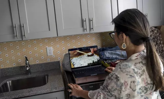 Dee Iraca, who was adopted as a baby out of South Korea to a family in the United States, watches a YouTube video on how to make kimbap, Korean seaweed rice rolls, Saturday, April 6, 2024, at her home in Davidson, N.C. (AP Photo/David Goldman)